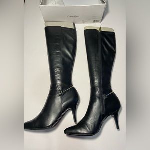 Tall boots, small heels, pointy front. It has a gold detail at heel base